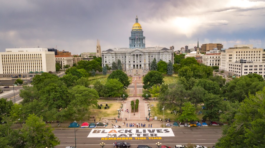 Protesters gather outside the Colorado state capitol as a Black Lives Matter banner is displayed in the street. (Credit: @josh_klein : www.jkcreativellc.com )