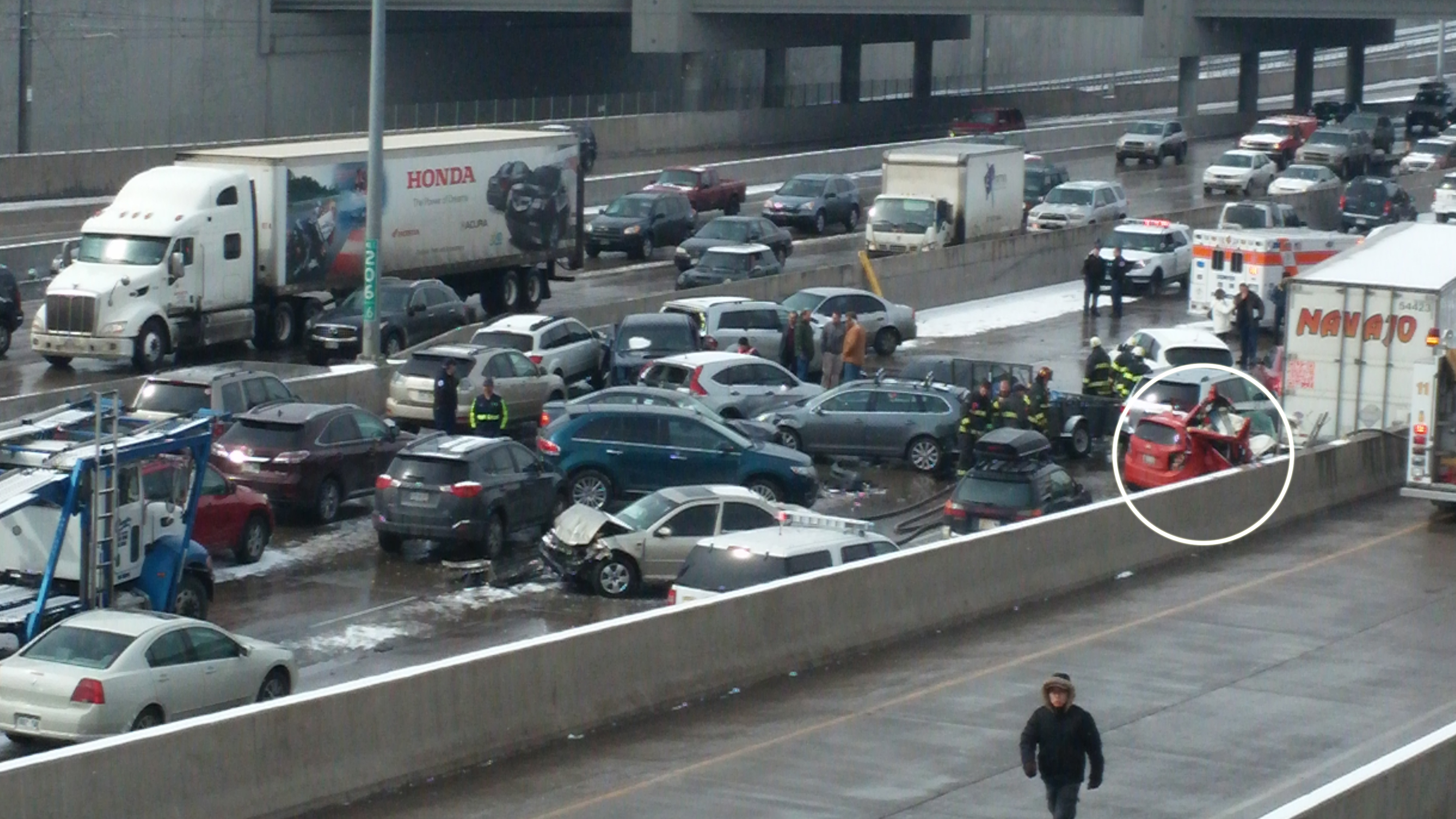 The small, red hatchback, circled, seen partially wedged against the I-25 median and partially buried by a semi-truck belonged to a woman killed in a 104-car pileup on the interstate in Denver on March 1, 2014.