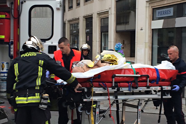 Firefighters carry an injured man on a stretcher in front of the offices of the French satirical newspaper Charlie Hebdo in Paris on January 7, 2015. (Photo: Philippe Dupeyrat/AFP/Getty Images)