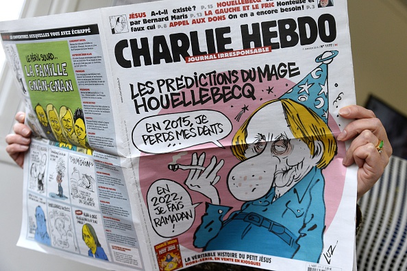 A person reads the latest issue of the French satirical newspaper Charlie Hebdo in Paris on January 7, 2015, after gunmen armed with Kalashnikovs and a rocket-launcher opened fire in the offices of the weekly in Paris, killing at least 12. (Photo: BERTRAND GUAY/AFP/Getty Images)