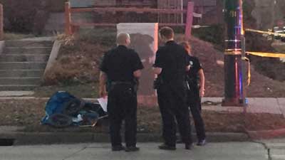 Denver Police stand next to crumpled stroller, hit by car, on University and Ohio.