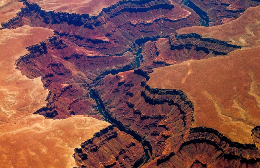 An aerial picture of the Grand Canyon in Arizona taken on July 1, 2013 from around 30,000 feet (10,000m). The Grand Canyon, considered one of the seven natural wonders of the world, is 277 miles (446 km) long, up to 18 miles (29 km) wide and attains a depth of over a mile (1.8km). Nearly two billion years of the Earth's geological history has been exposed as the Colorado River and its tributaries cut their channels through layer after layer of rock while the Colorado Plateau was uplifted. While the specific geologic processes and timing that formed the Grand Canyon are the subject of debate by geologists, recent evidence suggests the Colorado River established its course through the canyon at least 17 million years ago. Since that time, the Colorado River continued to erode and form the canyon to its present-day configuration. AFP PHOTO/JOE KLAMAR (Photo credit should read JOE KLAMAR/AFP/Getty Images)