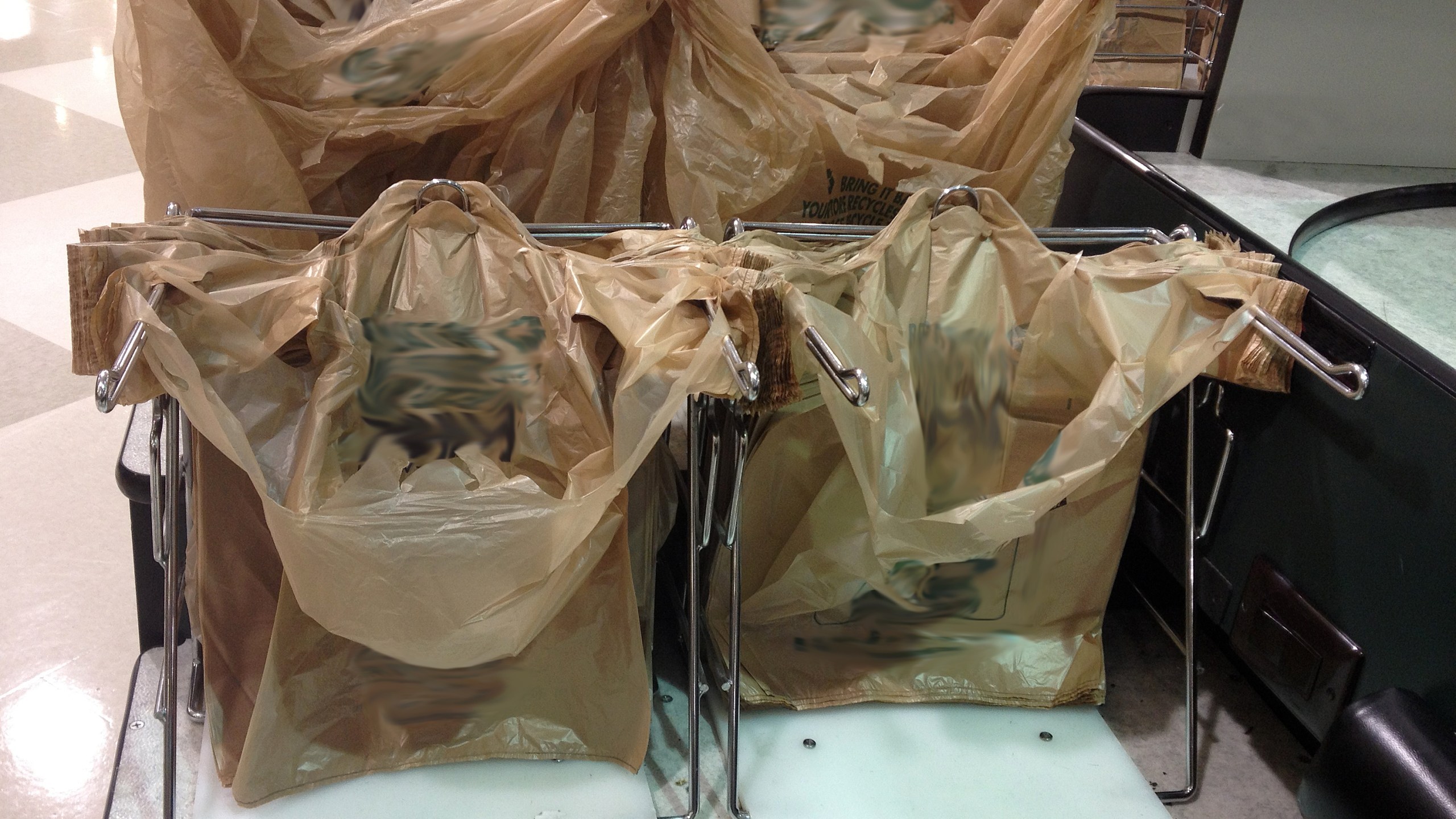 Plastic bags at grocery store checkout counter.