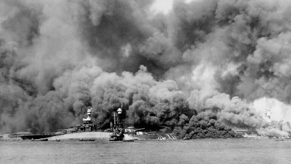 A black-and-white photo of the capsized USS Oklahoma during the Pearl Harbor attack