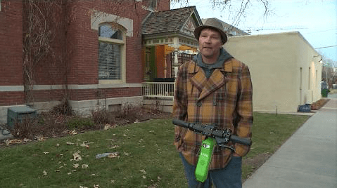 Sammy Sweet, Denver's top Lime scooter rider, stands with a scooter on the sidewalk