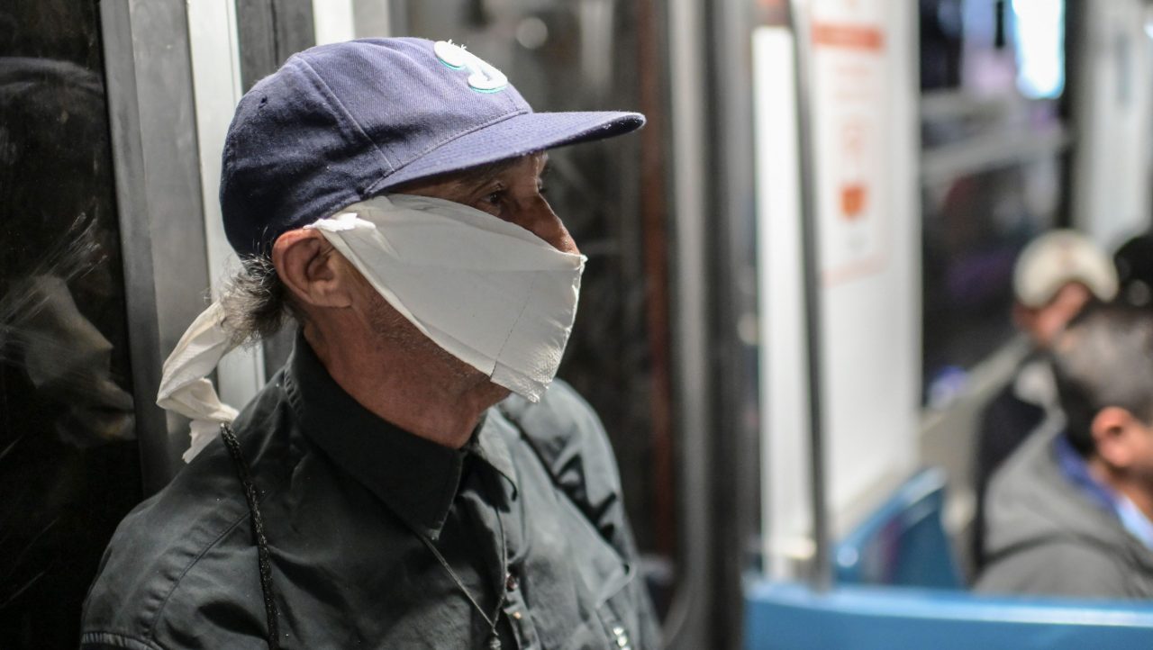 A man wearing a paper-face mask travels on the subway in Mexico City, on April 2, 2020.