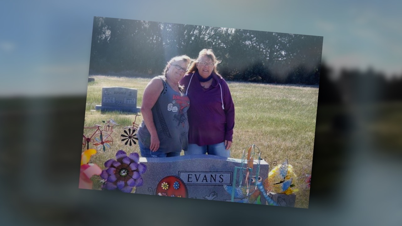 Tracy Dilka of Weld County and her sister Teresa visit their mother's grave in Kansas. Their mother, Marty Evans, died after contracting COVID-19.