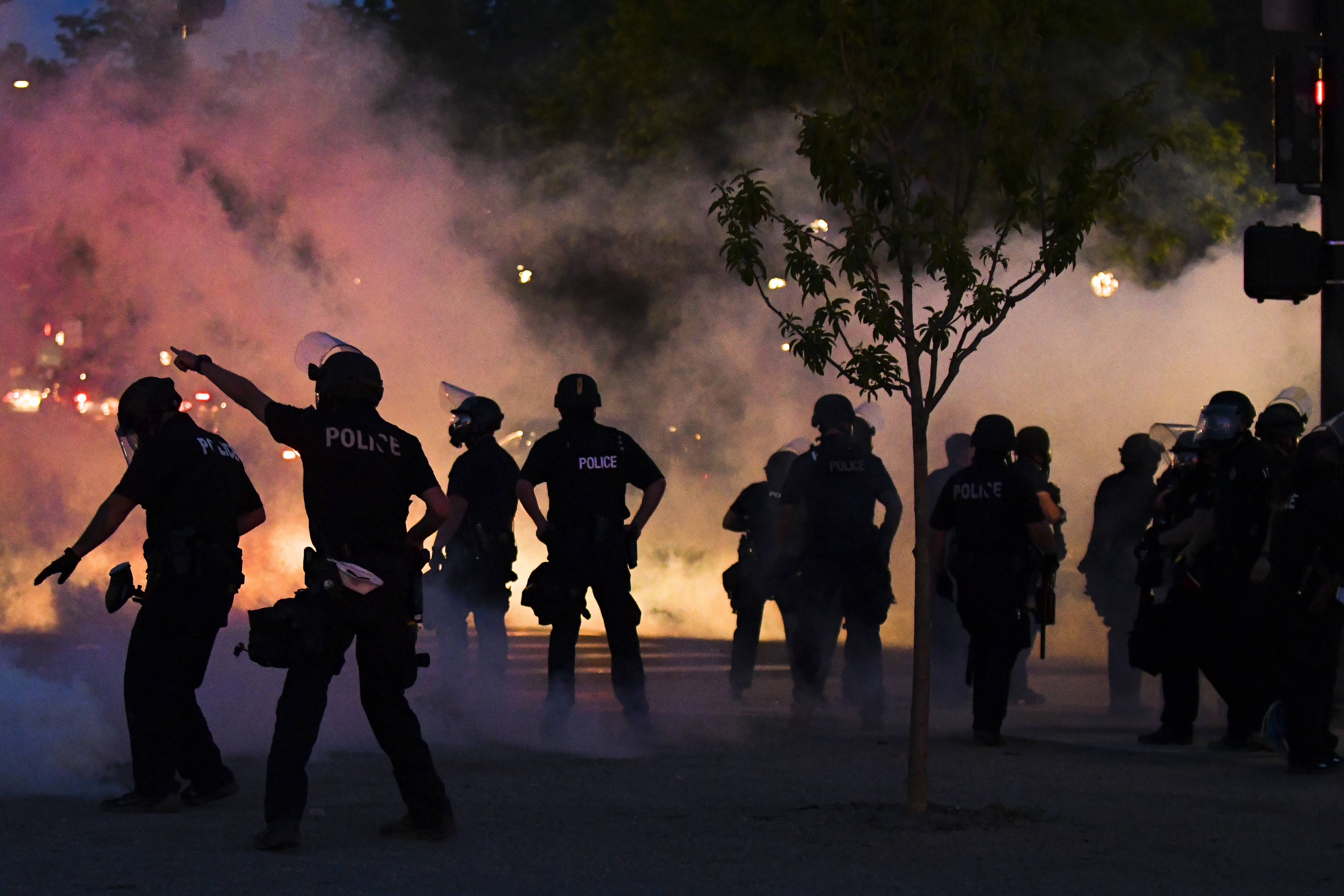 Police officers fire tear gas at protesters near the Colorado state capitol during a protest at night