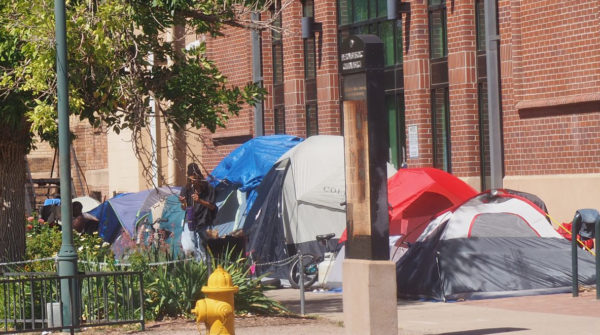 Tents along a city sidewalk during the day