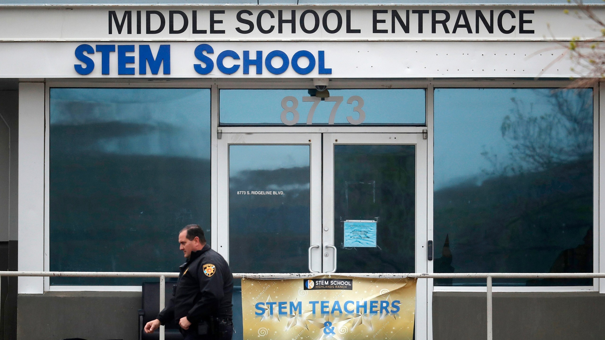 a Douglas County, Colo., Sheriff's deputy walks past the doors of the STEM School Highlands Ranch