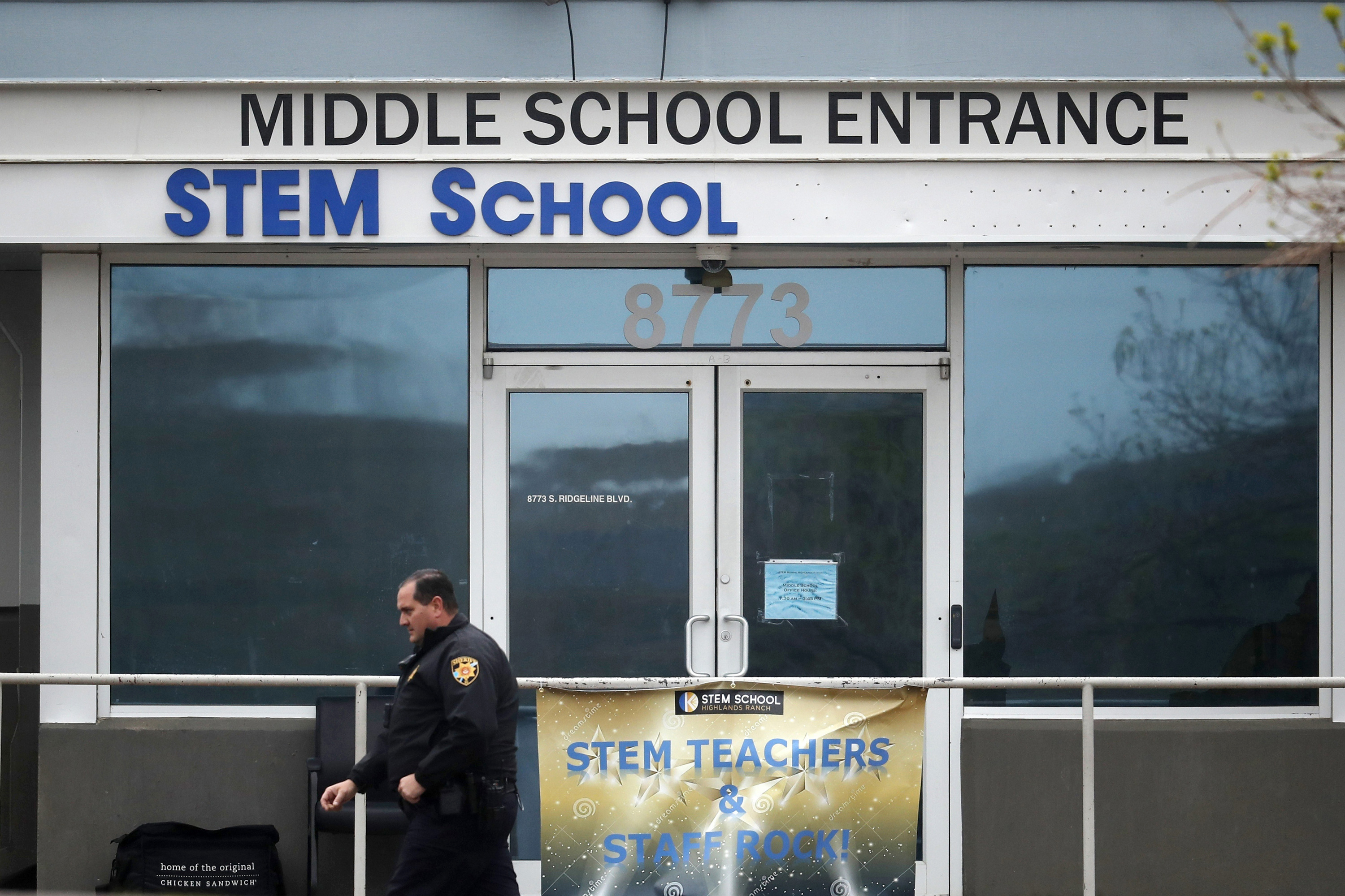 a Douglas County, Colo., Sheriff's deputy walks past the doors of the STEM School Highlands Ranch