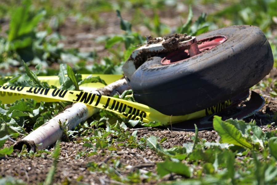 Closeup of police tape and a plane wheel on grass and dirt