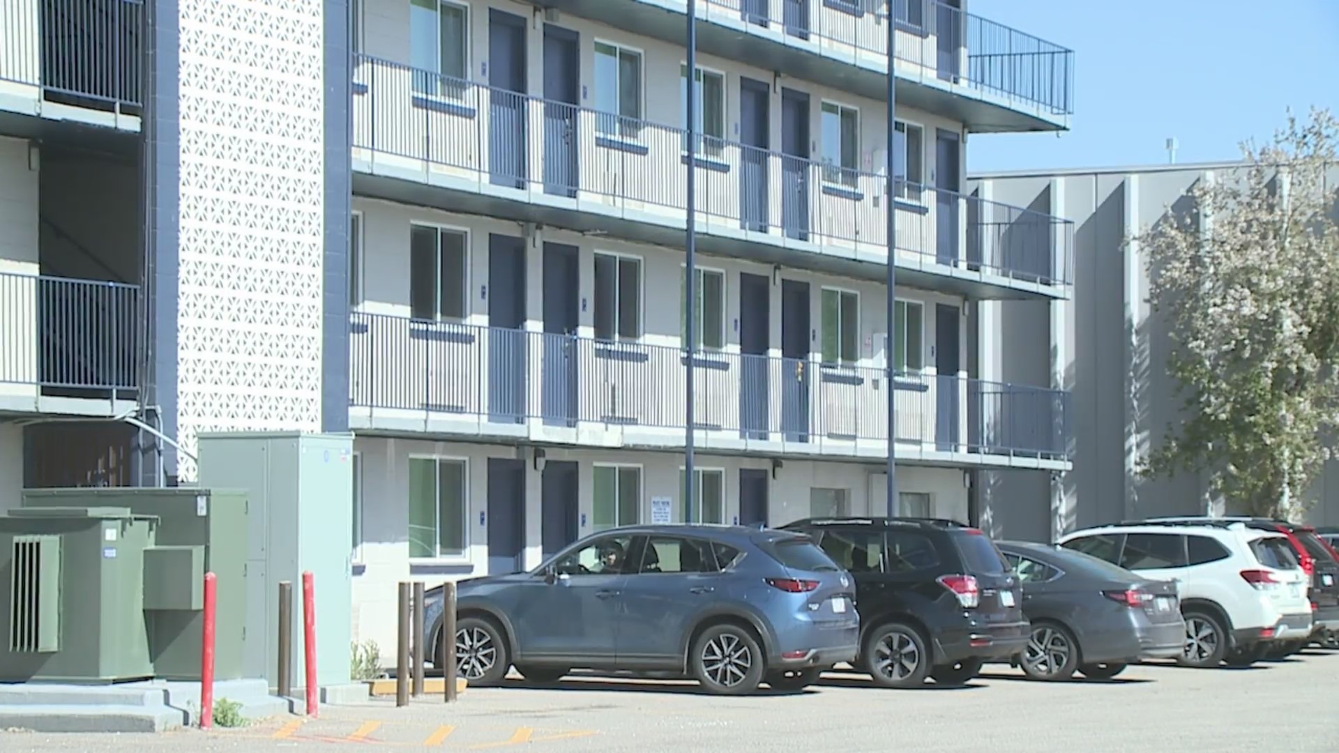 Exterior of the Stay Inn hotel in downtown Denver with cars in the parking lot