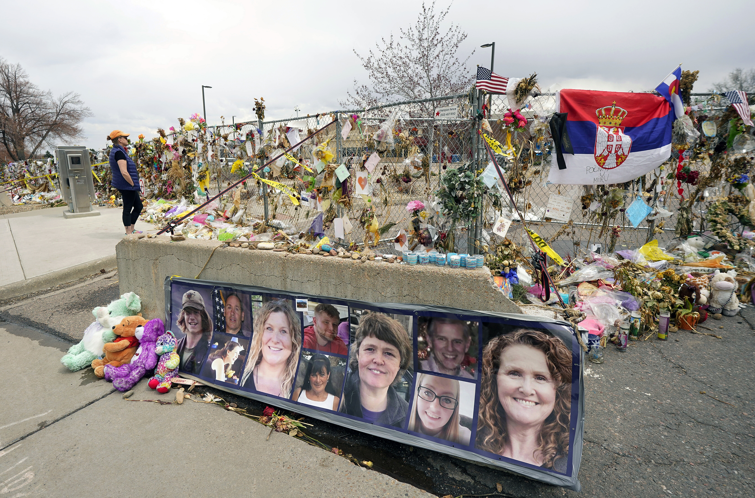 hotographs of the 10 victims of a mass shooting in a King Soopers grocery store are posted on a cement barrier outside the supermarket