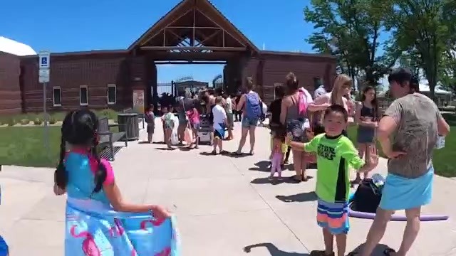 Line of pool goers outside of a pool entrance