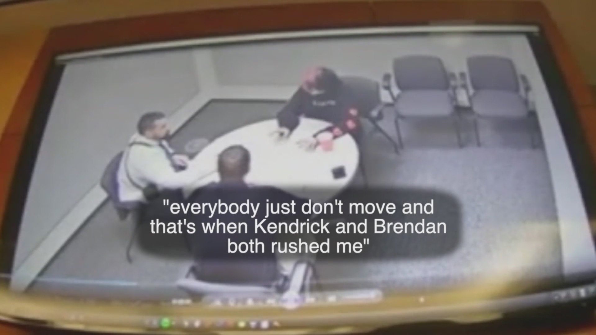 Surveillance vide of three people talking at a table