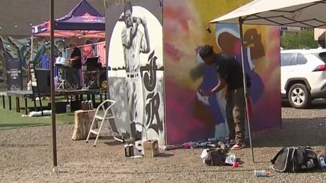 A person spray-painting a large canvas