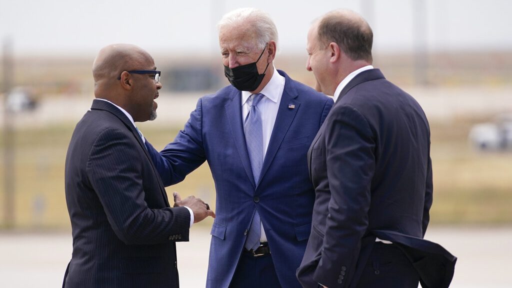 President Joe Biden talks with Colorado Gov. Jared Polis, right, and Denver Mayor Michael B. Hancock after arriving on Air Force One at Denver International Airport Tuesday, Sept. 14, 2021, in Denver.