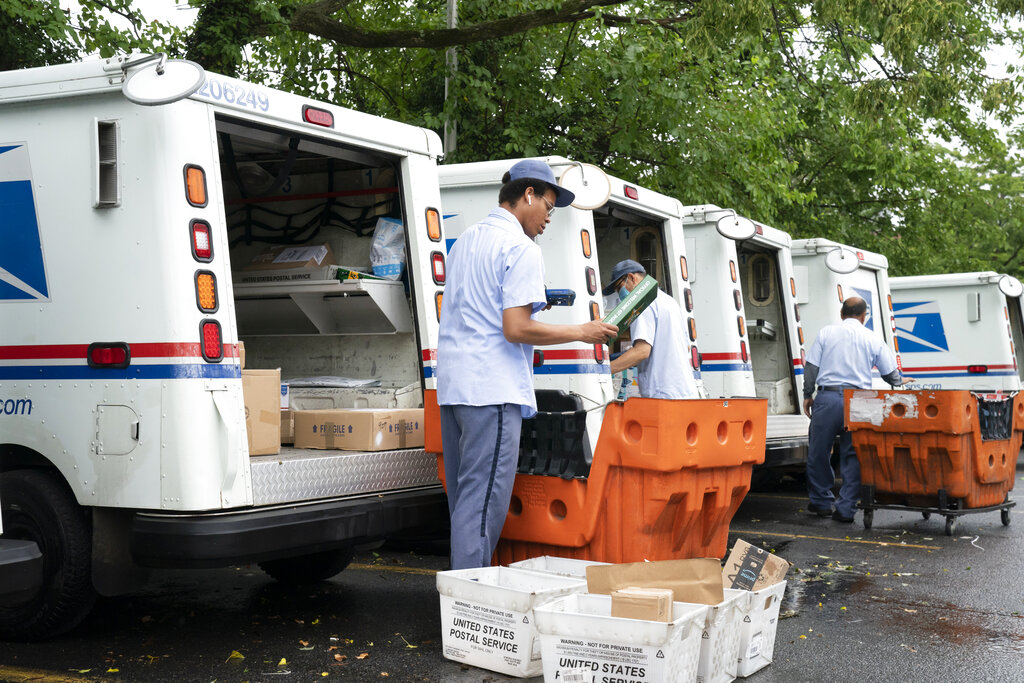 Letter carriers load mail trucks for deliveries