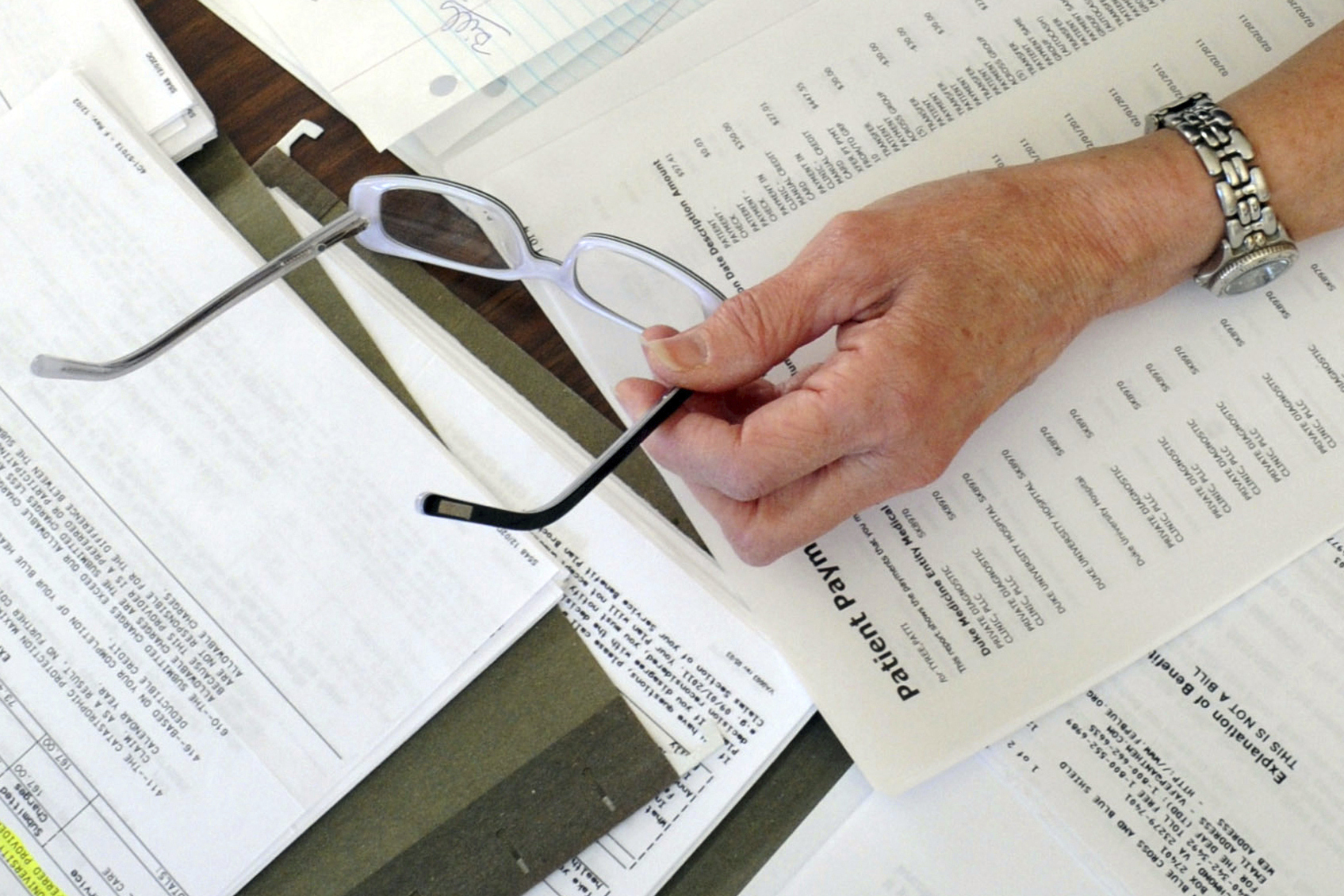 medical bills and other records are spread out on a kitchen table