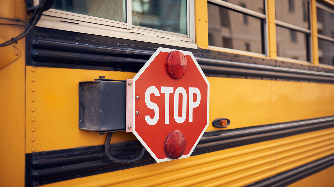 Side view of a school bus and its stop signal