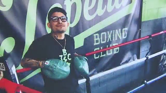 Portrait of Joaquin Romero with boxing gloves at a boxing gym