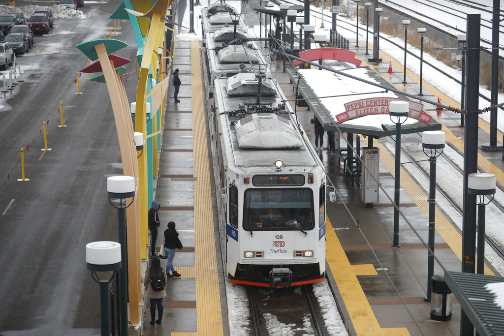 Passengers wait for light rail along tracks