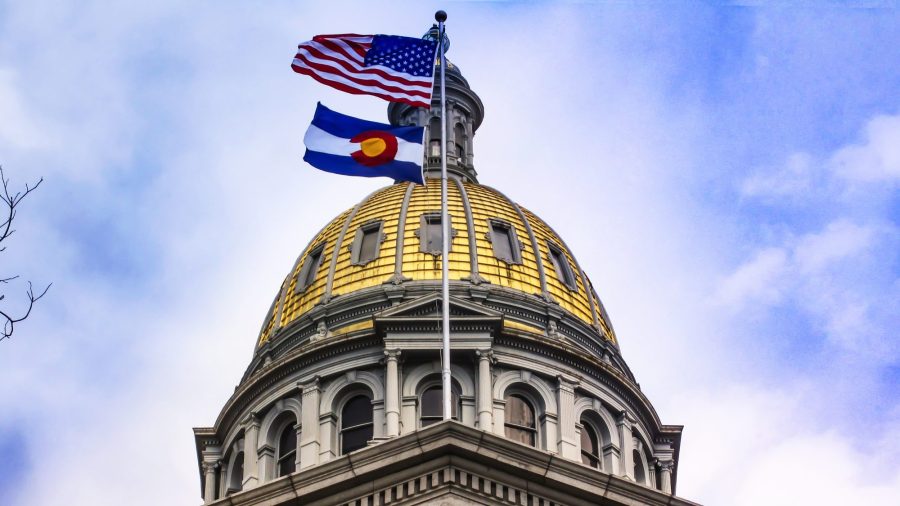 Flags fly in front of the gold dome of the Colorado State Capitol Building in Denver, in this file photo.