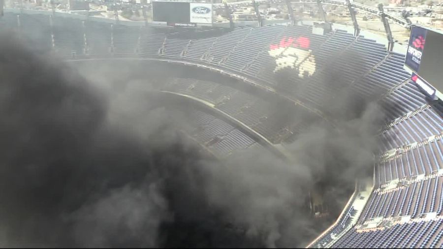 Smoke is seen from a fire at Empower Field at Mile High