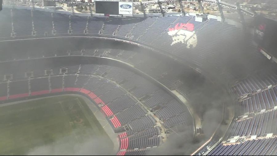 Smoke is seen from a fire at Empower Field at Mile High