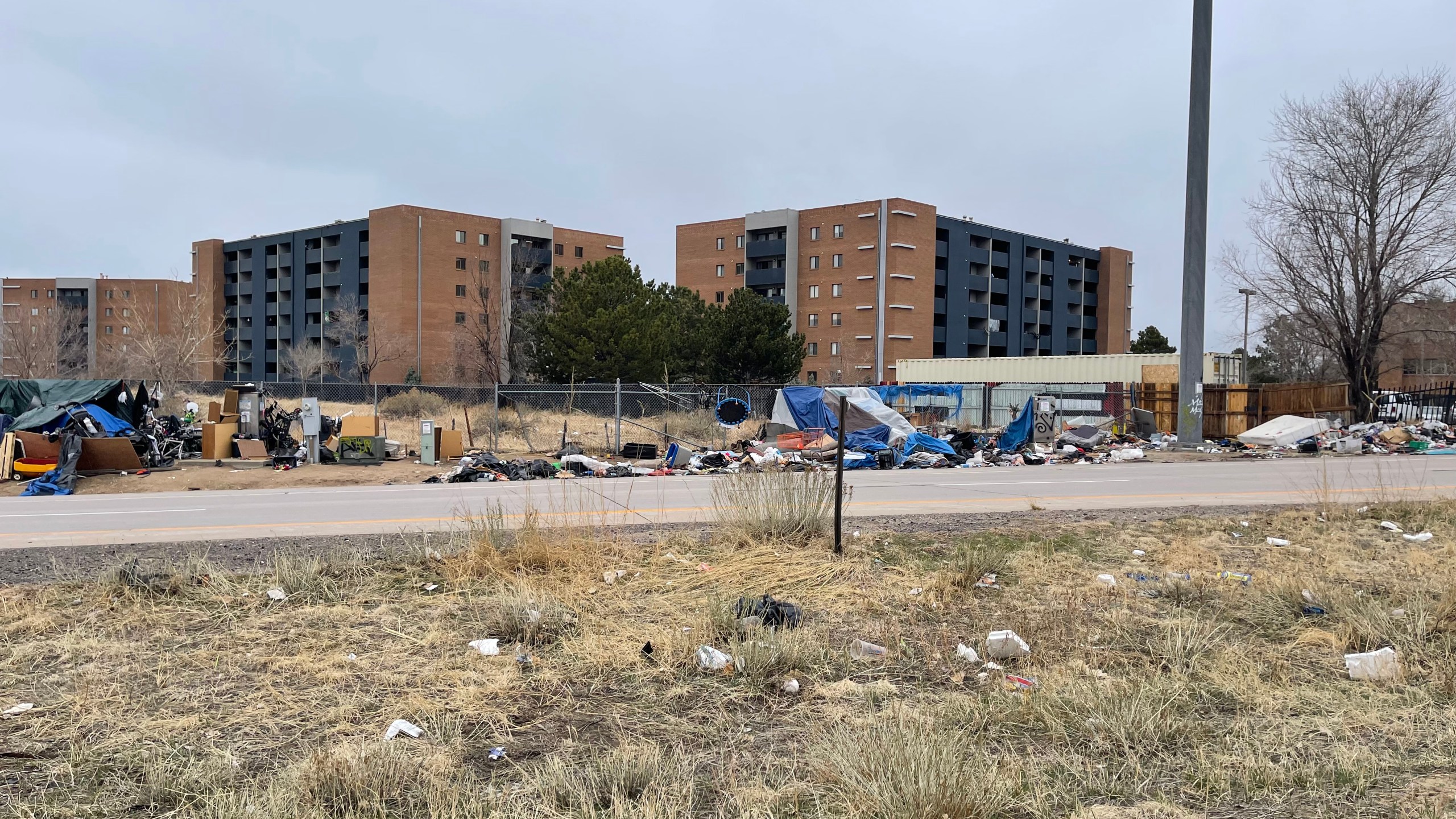 Aurora homeless camp along Interstate 25 traffic in daylight