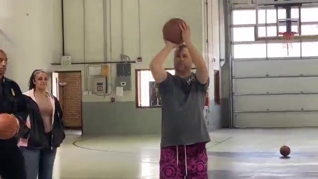 Man in position to throw a basketball in a gym during the day