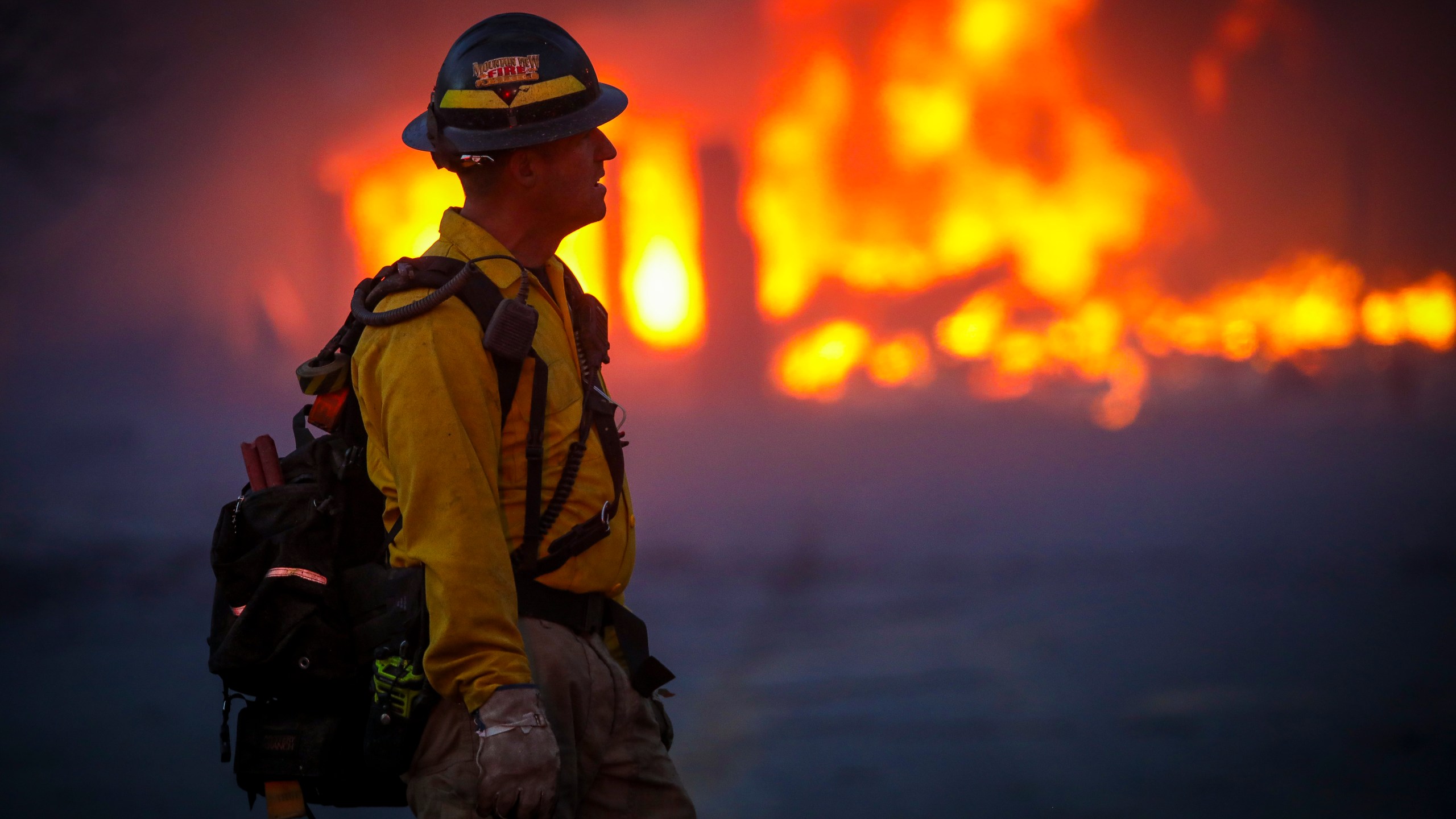 A Mountain View wildland firefighter walks through the smoke and haze