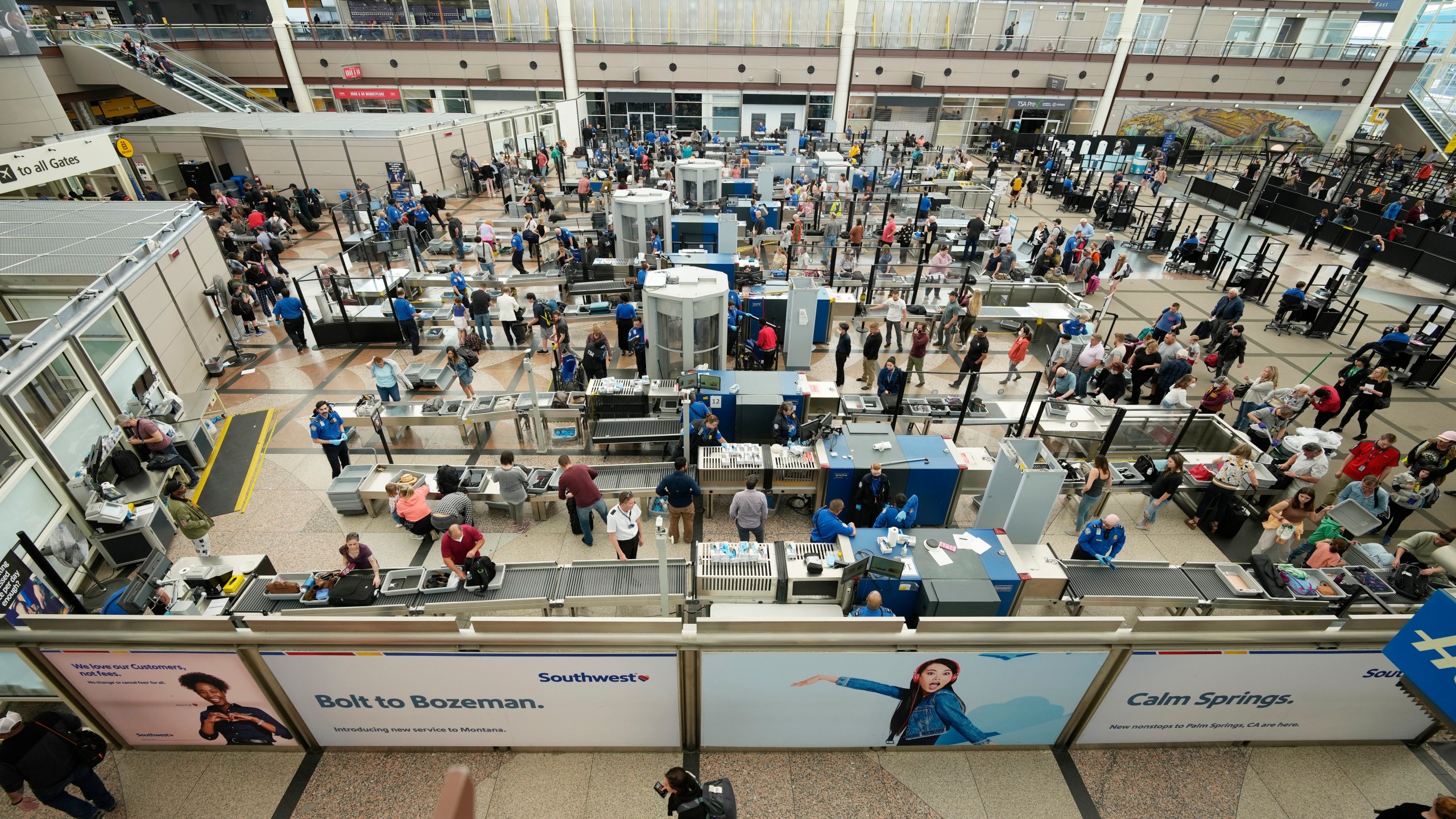 Travelers queue up at the south security checkpoint in the main terminal of Denver International Airport