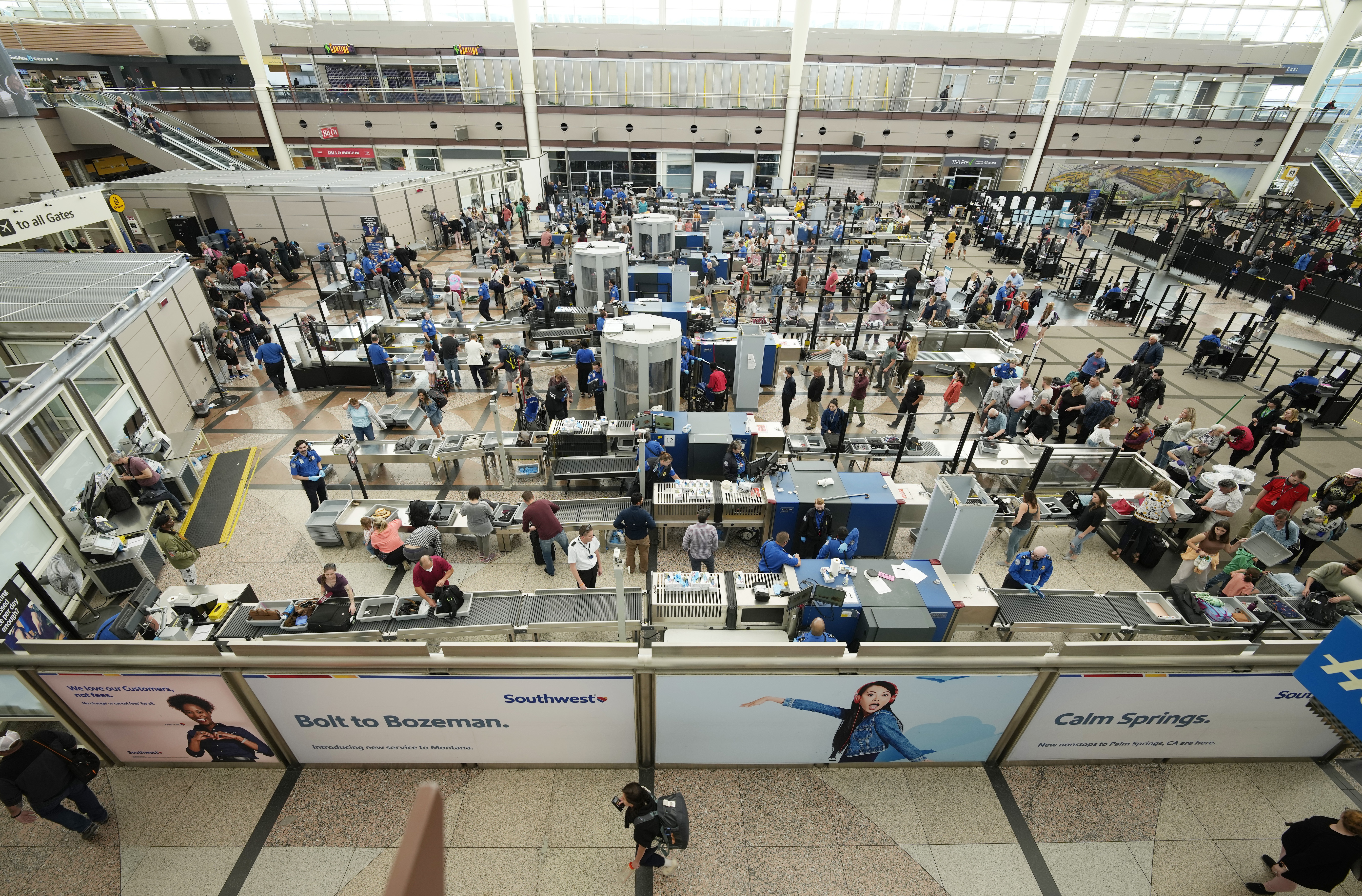 Travelers queue up at the south security checkpoint in the main terminal of Denver International Airport