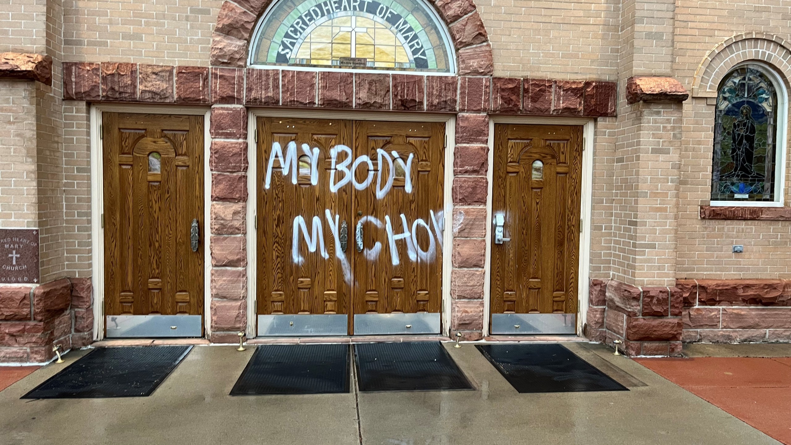 Graffiti on Boulder Catholic church doors