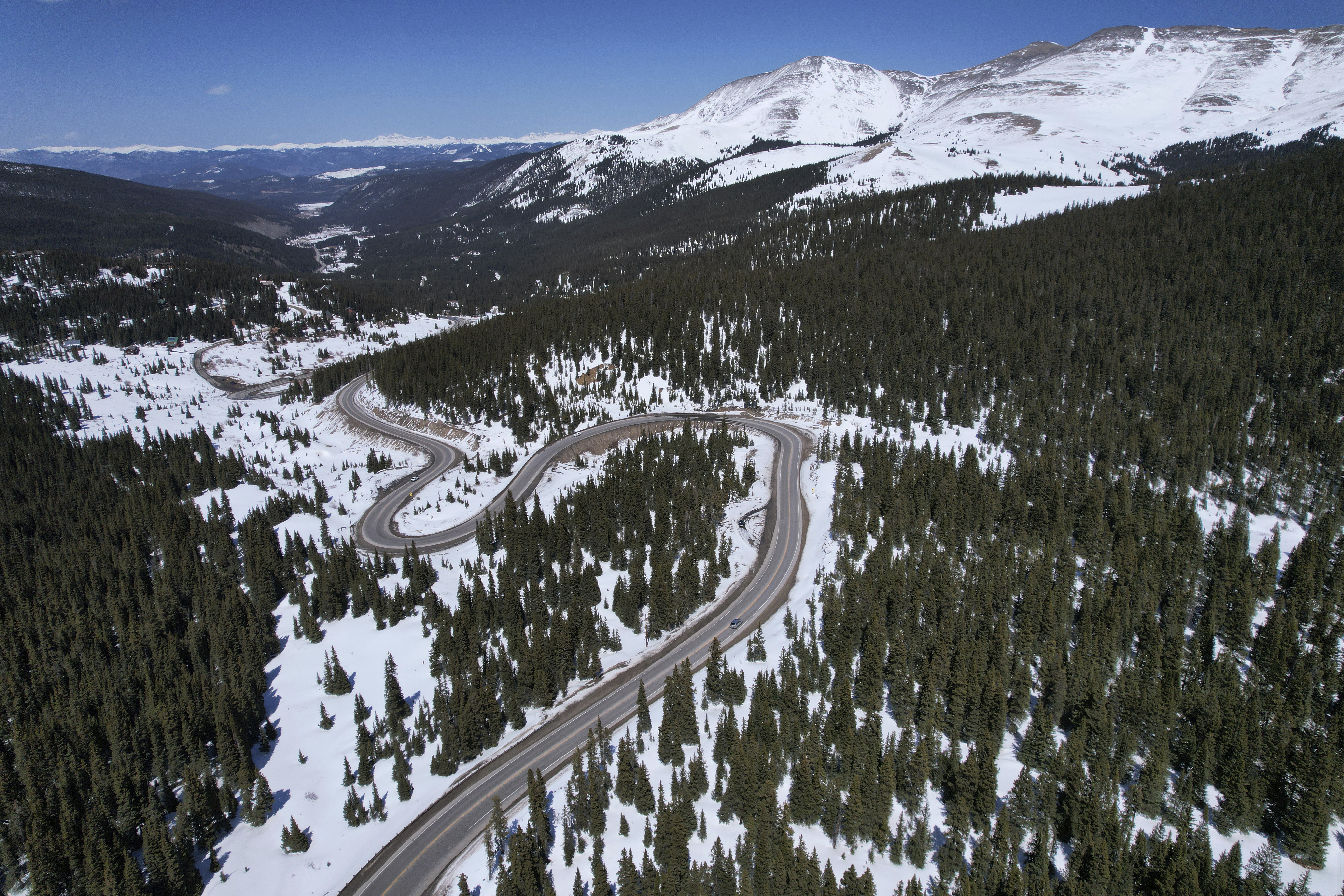 A road winds through the snow-covered Rocky Mountains at Hoosier Pass as seen from the air