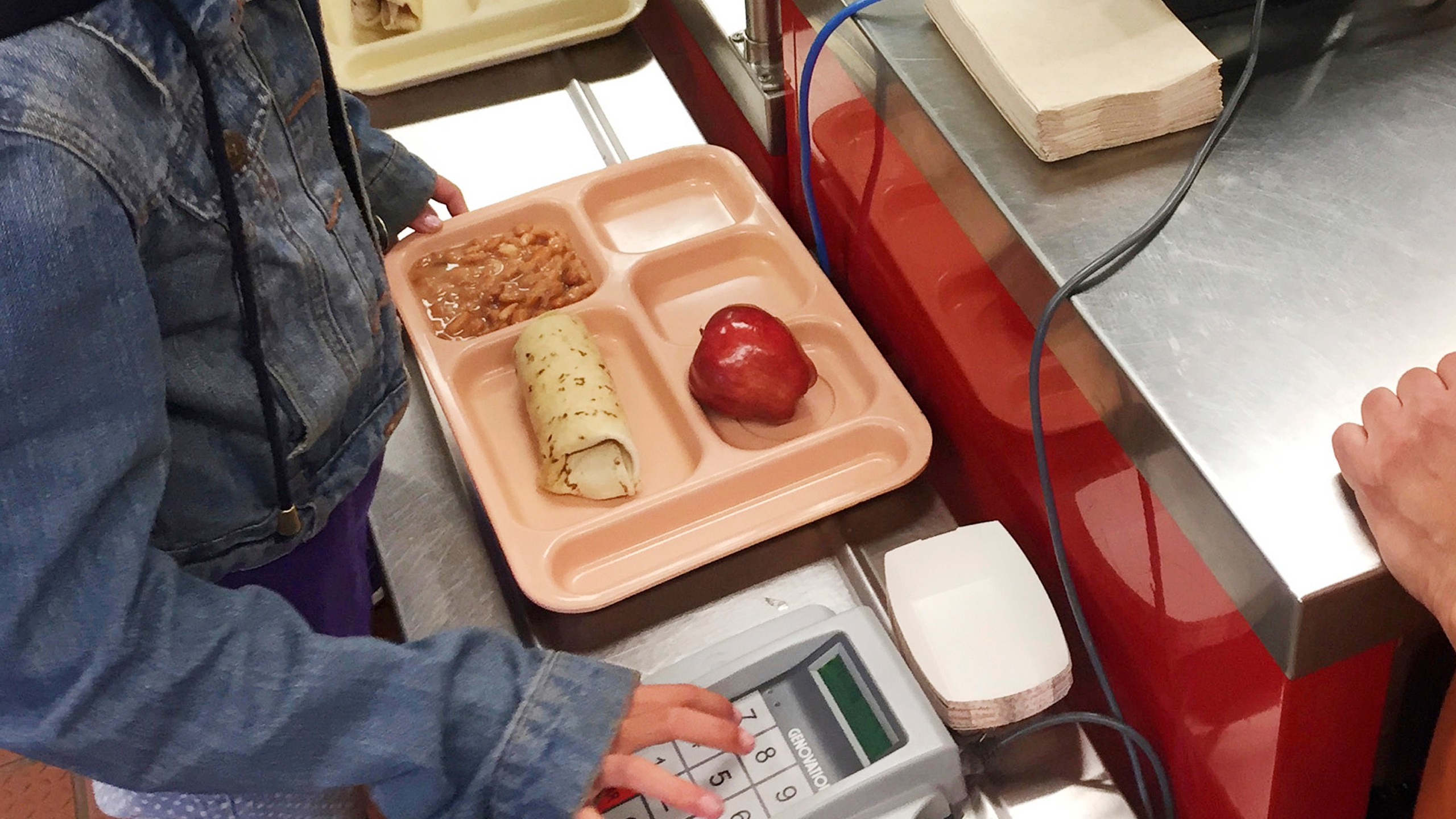 a child punches in her student identification to pay for a school meal