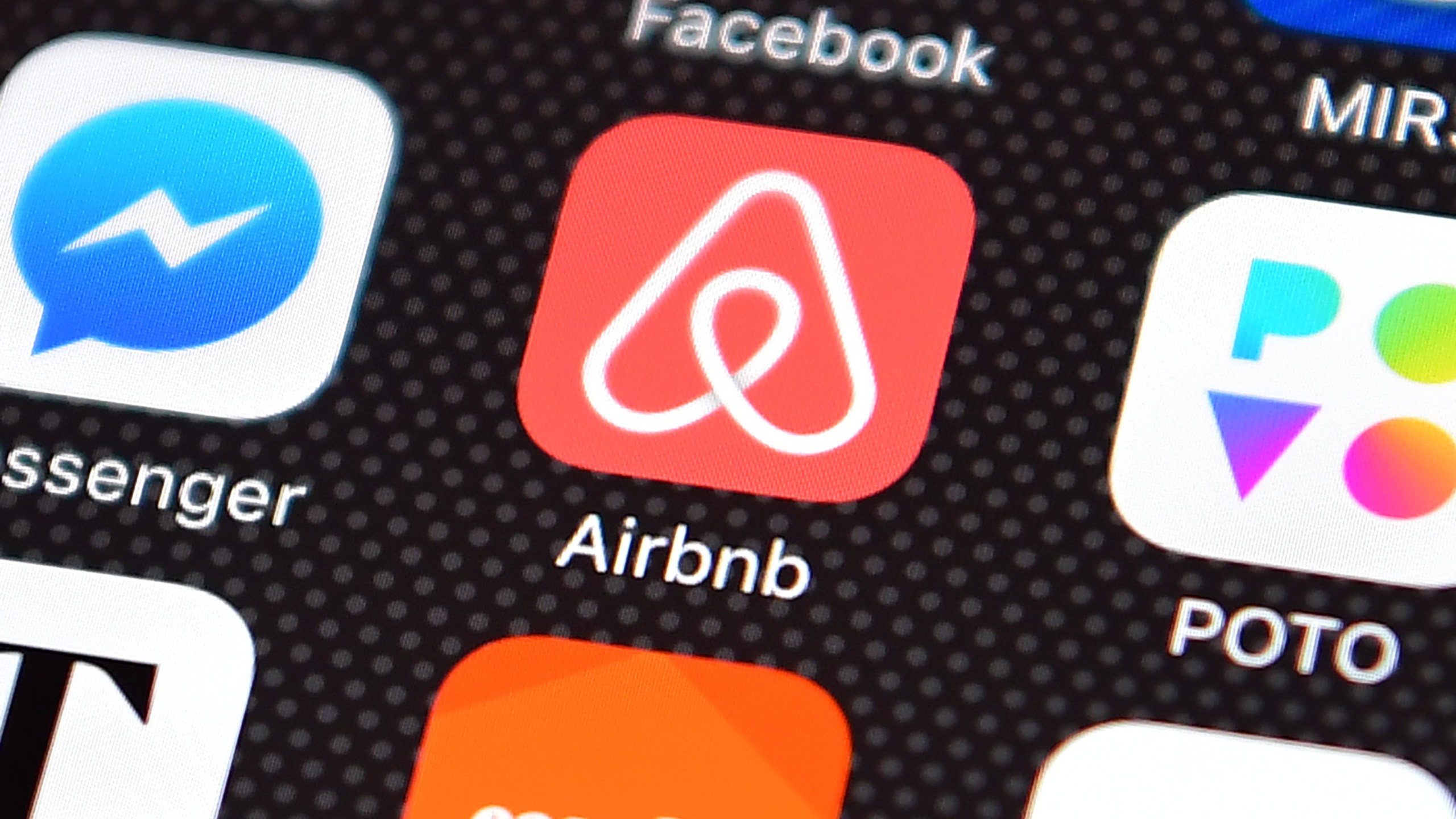 Phone screen with app logos, including Airbnb