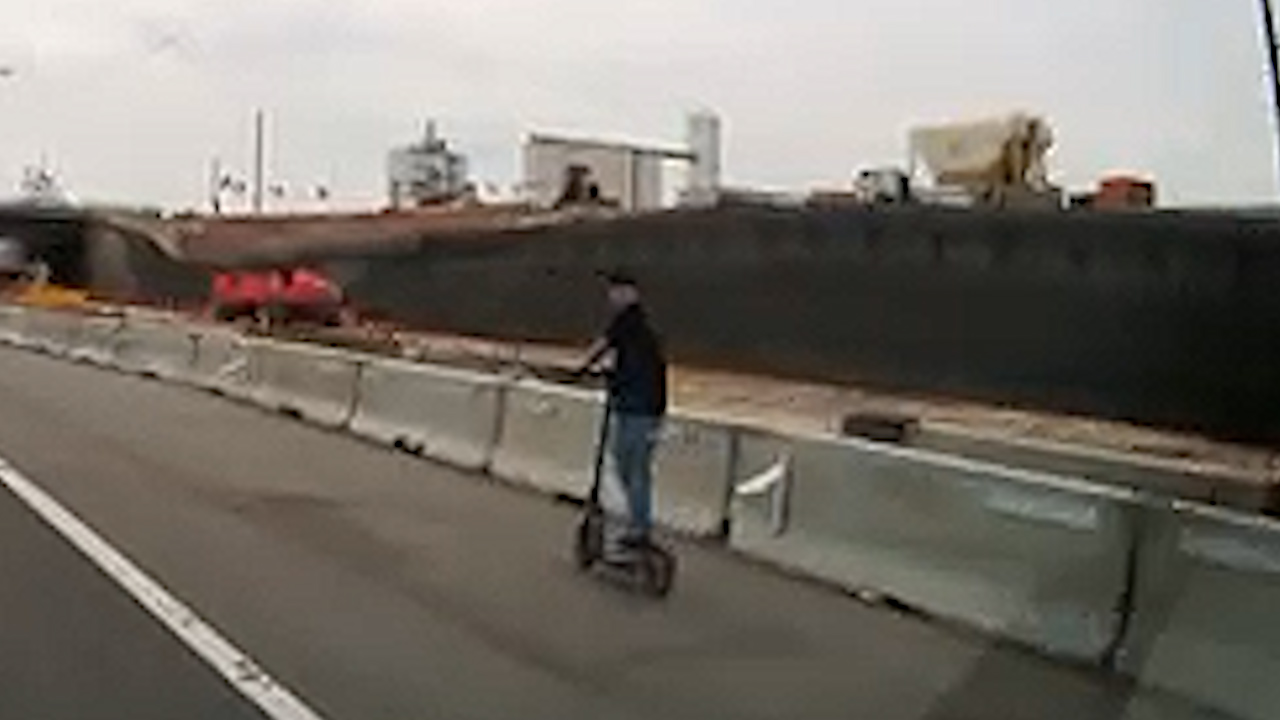 An Uber driver's dashcam captures a man riding an e-scooter through an I-70 construction zone.