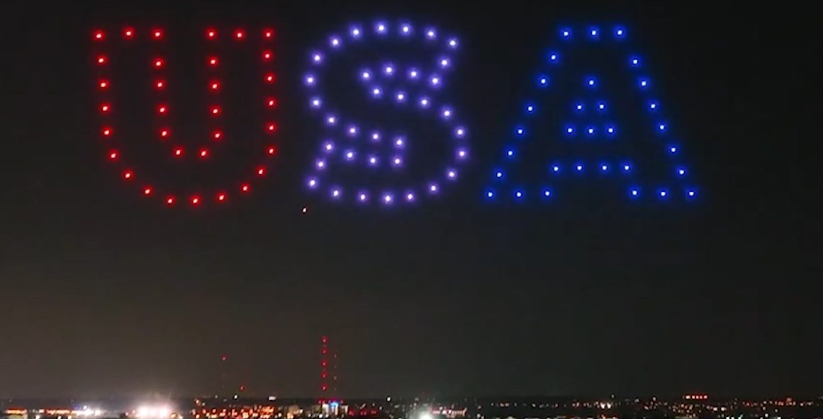 Dozens of drones spell out "USA" in the night sky as part of a Hire UAV Pro display.