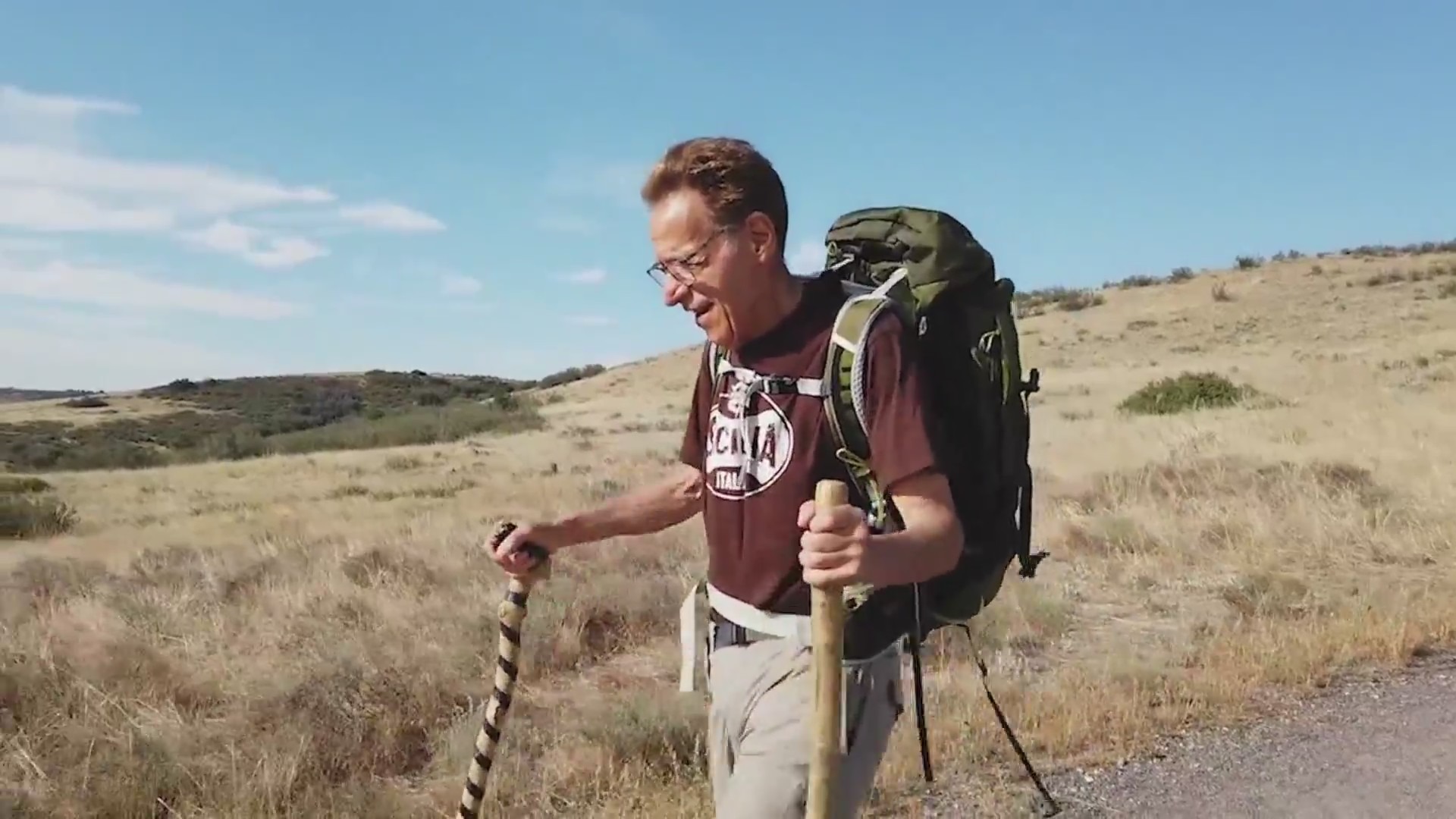 Man on trail with hiking poles and backpack