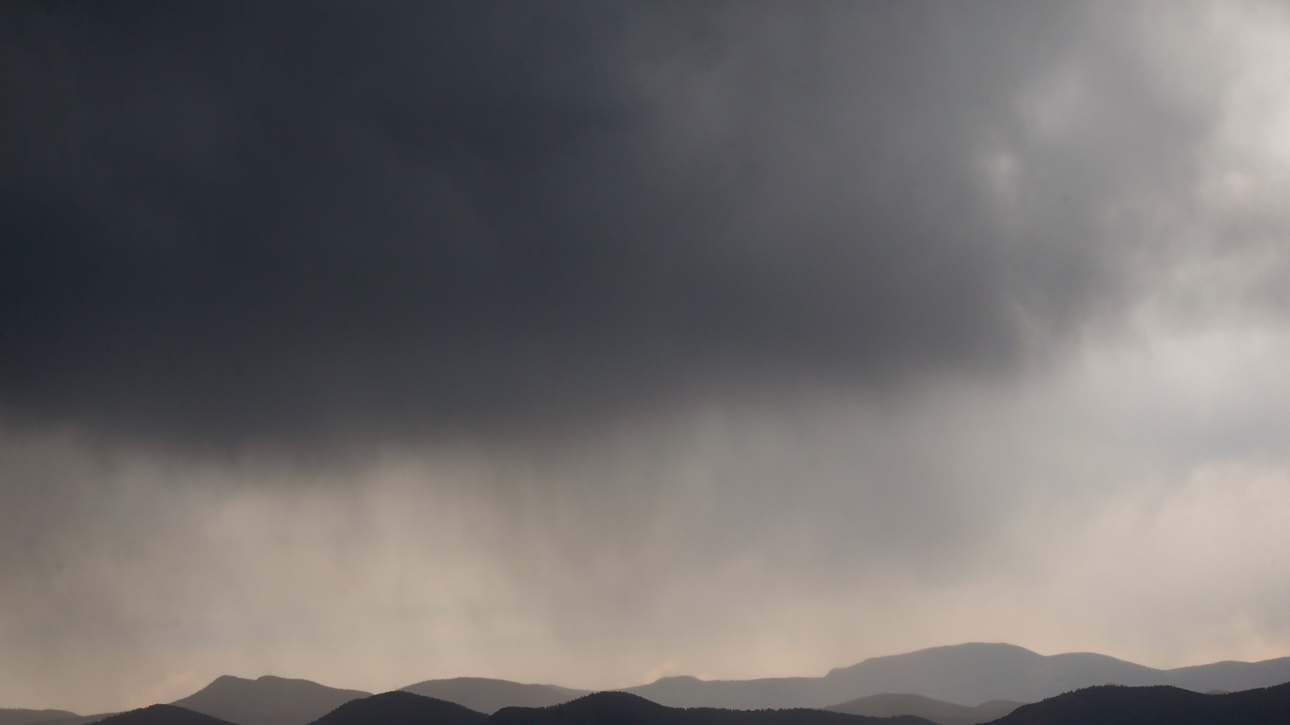 Storm clouds pass over the Front Range of the Rockies, seen from Denver