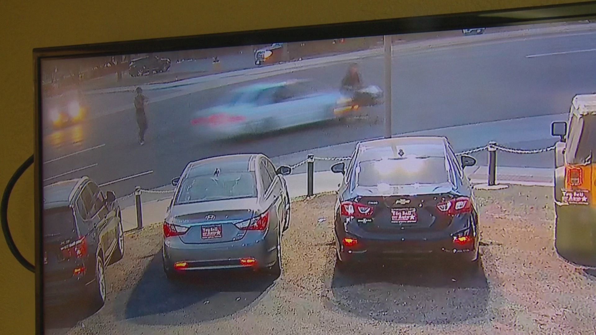 A woman runs with a toddler across several lanes of traffic