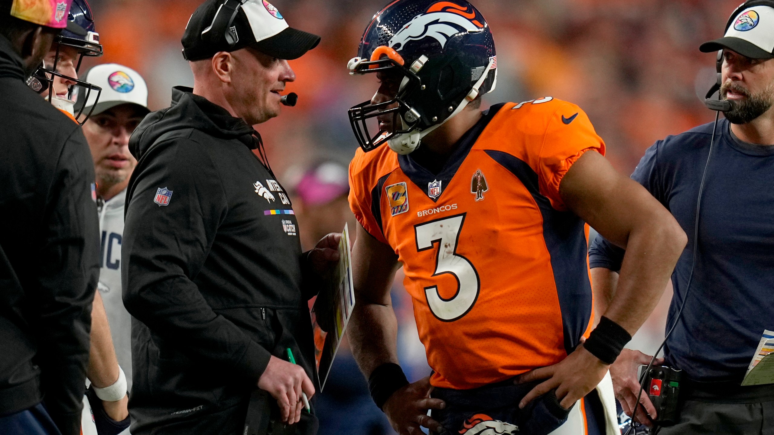 Russell Wilson (3) talks with head coach Nathaniel Hackett