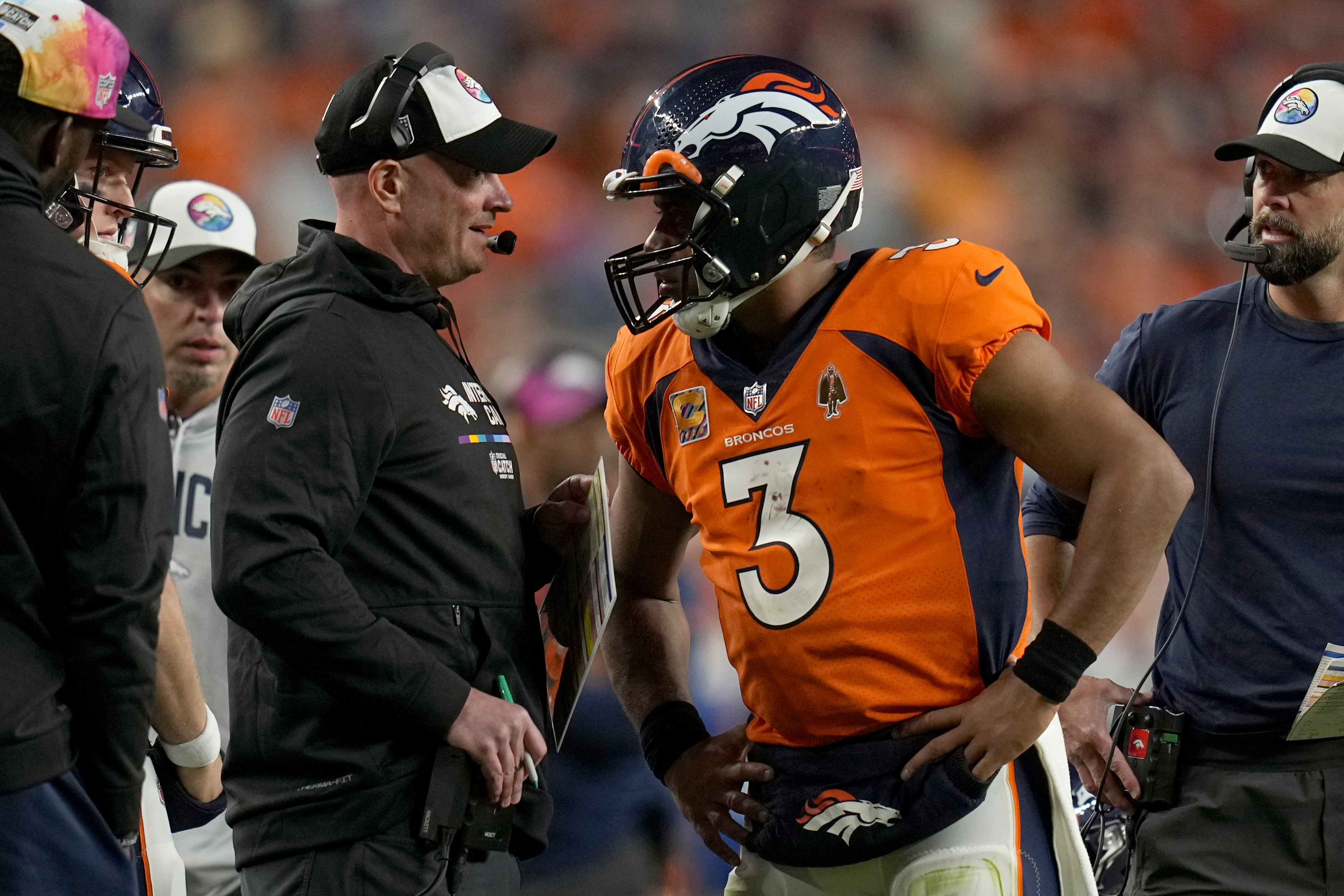 Russell Wilson (3) talks with head coach Nathaniel Hackett