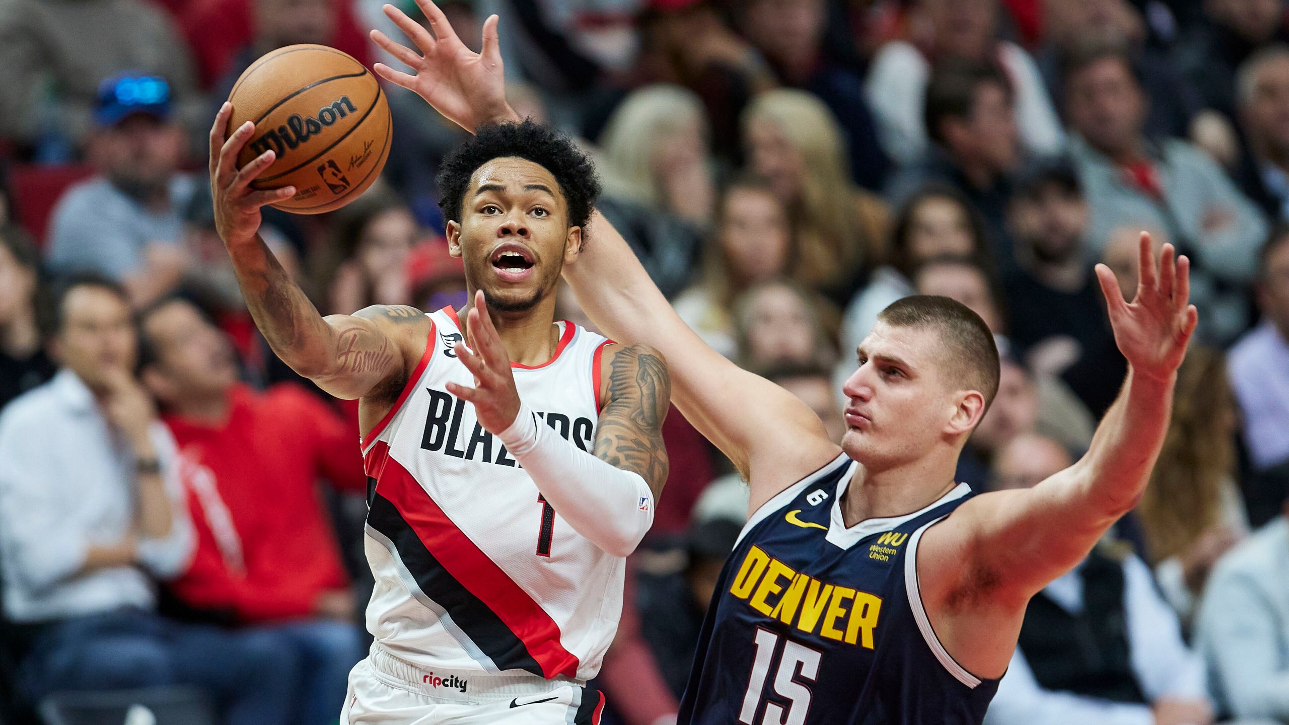 Anfernee Simons, left, shoots over Nikola Jokic