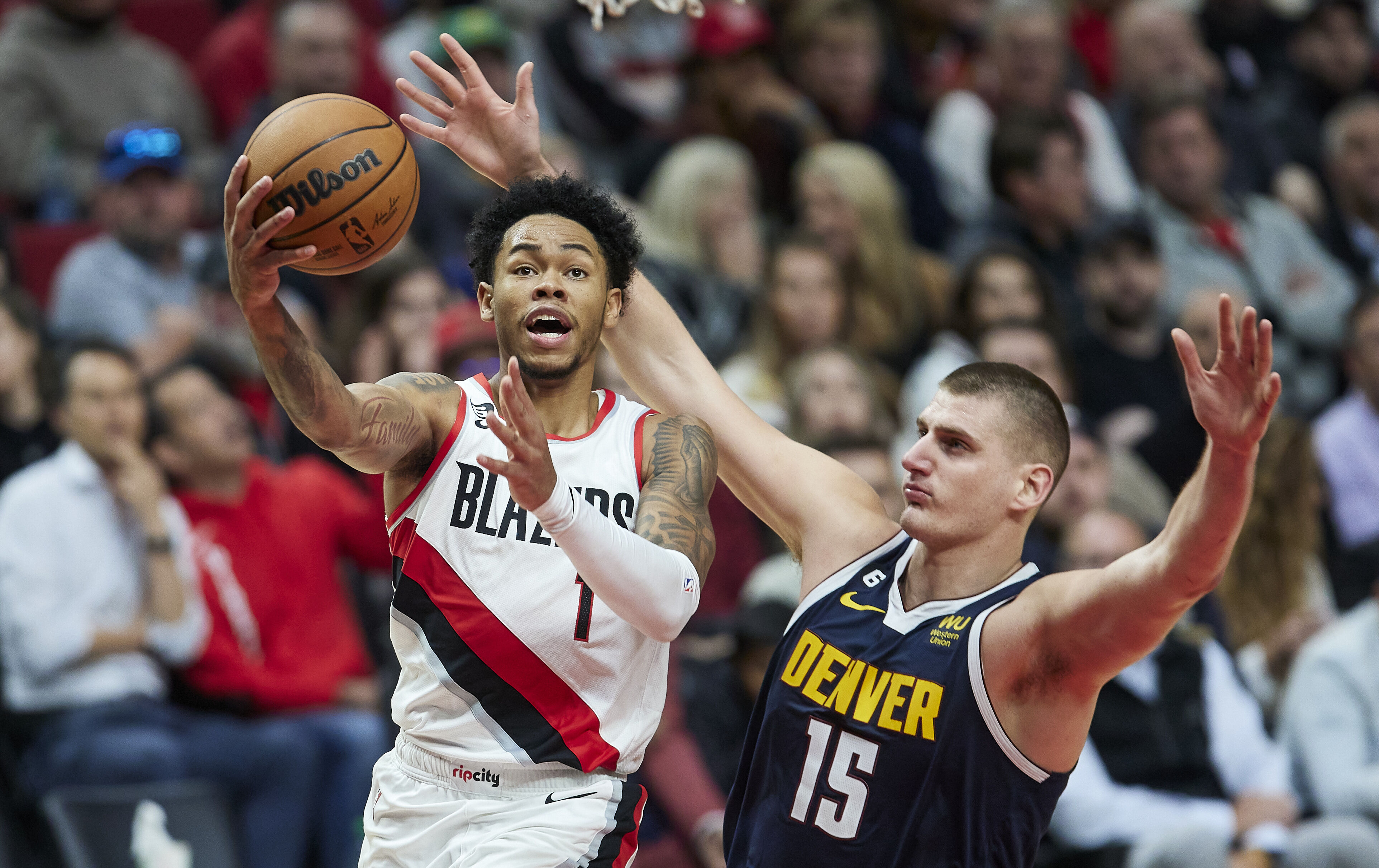 Anfernee Simons, left, shoots over Nikola Jokic