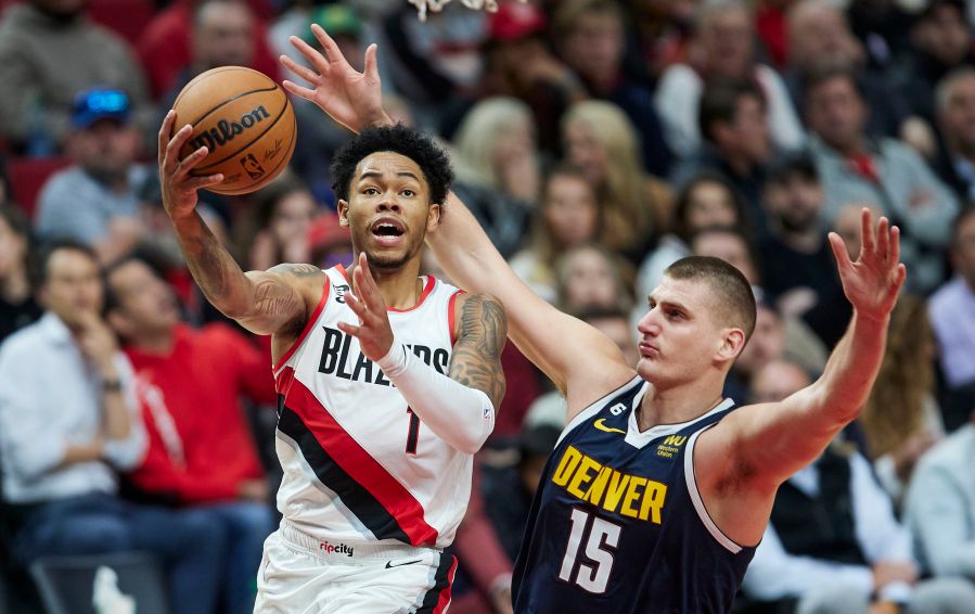 Anfernee Simons, left, shoots over Nikola Jokic