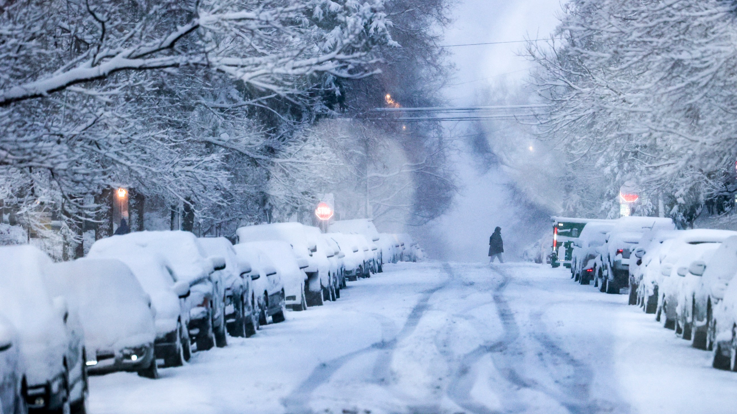 A person crosses a snowy street